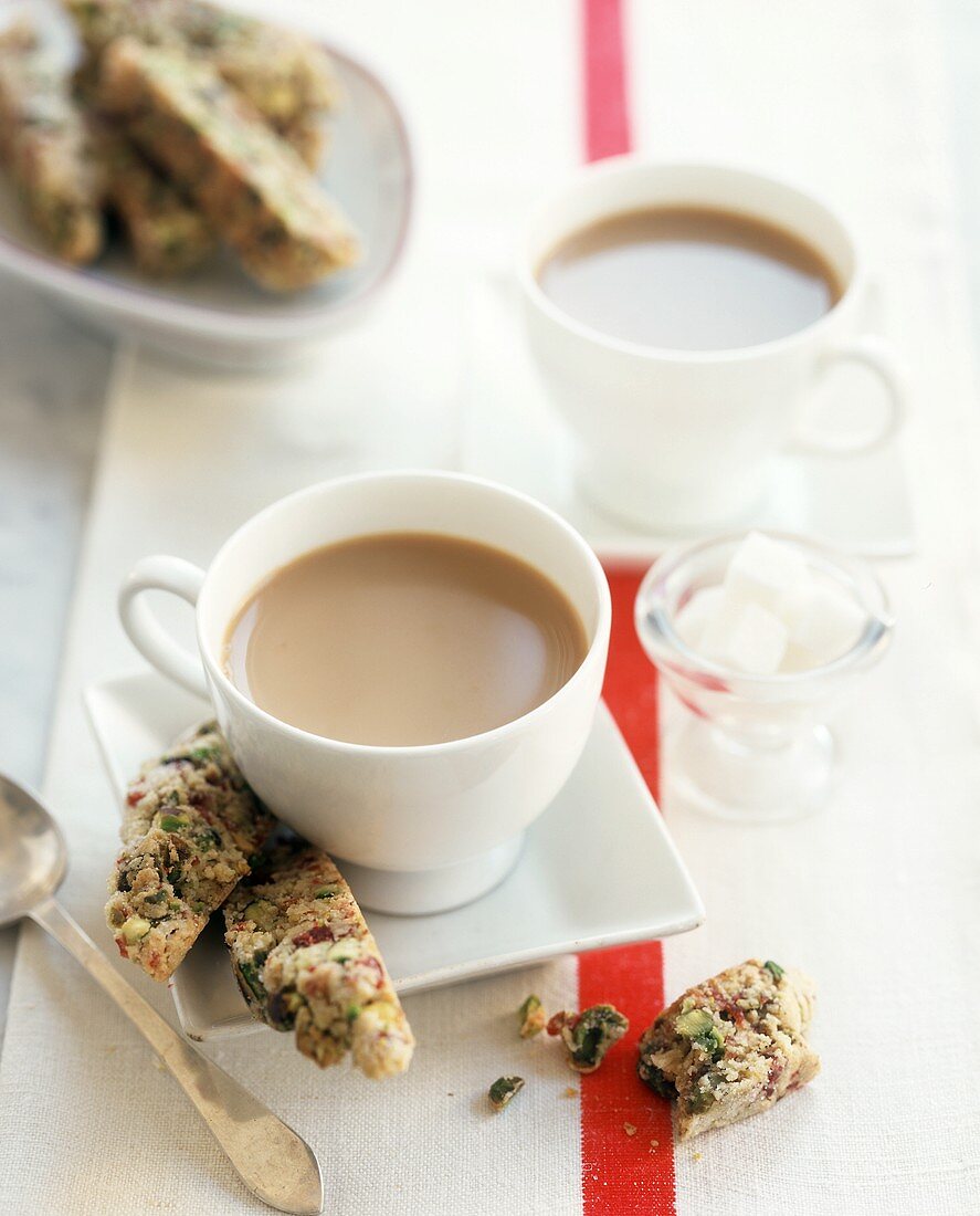 Two cups of coffee with cranberry & pistachio biscotti