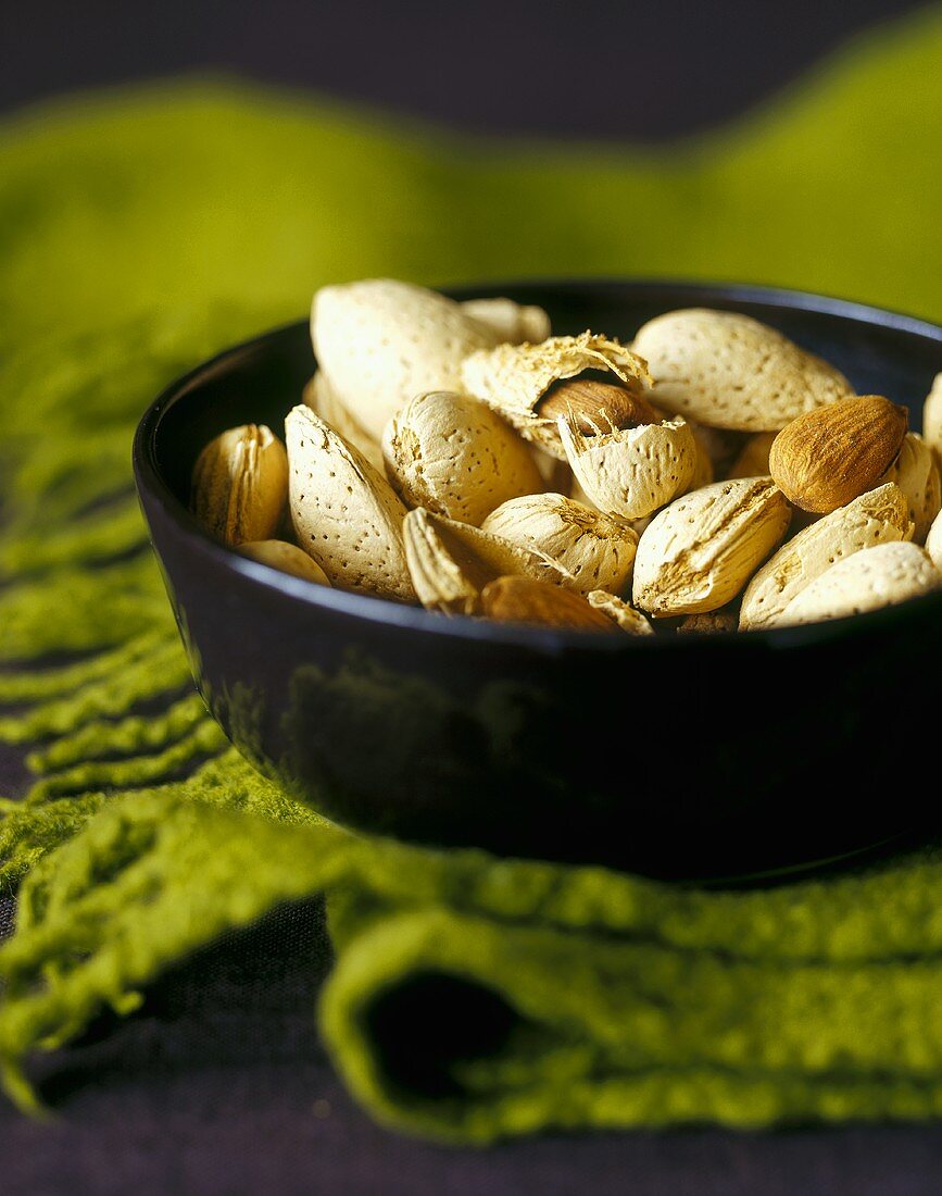 Almonds, In and Out of the Shell, in a Black Bowl