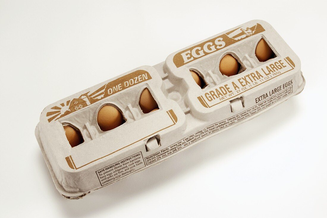 Zwölf braune Eier in Eierkarton