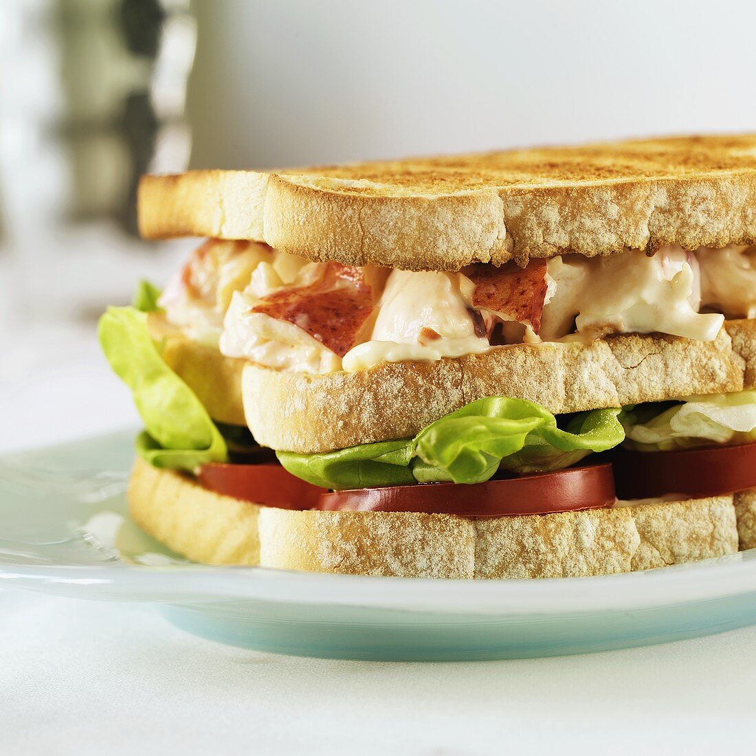 A Lobster Sandwich on Toasted Bread with Lettuce and Tomato