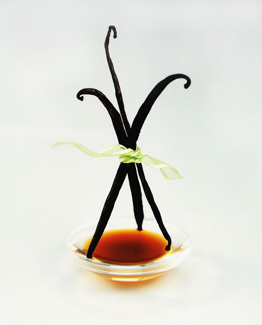 Vanilla Beans Standing Upright on a Bowl of Extract