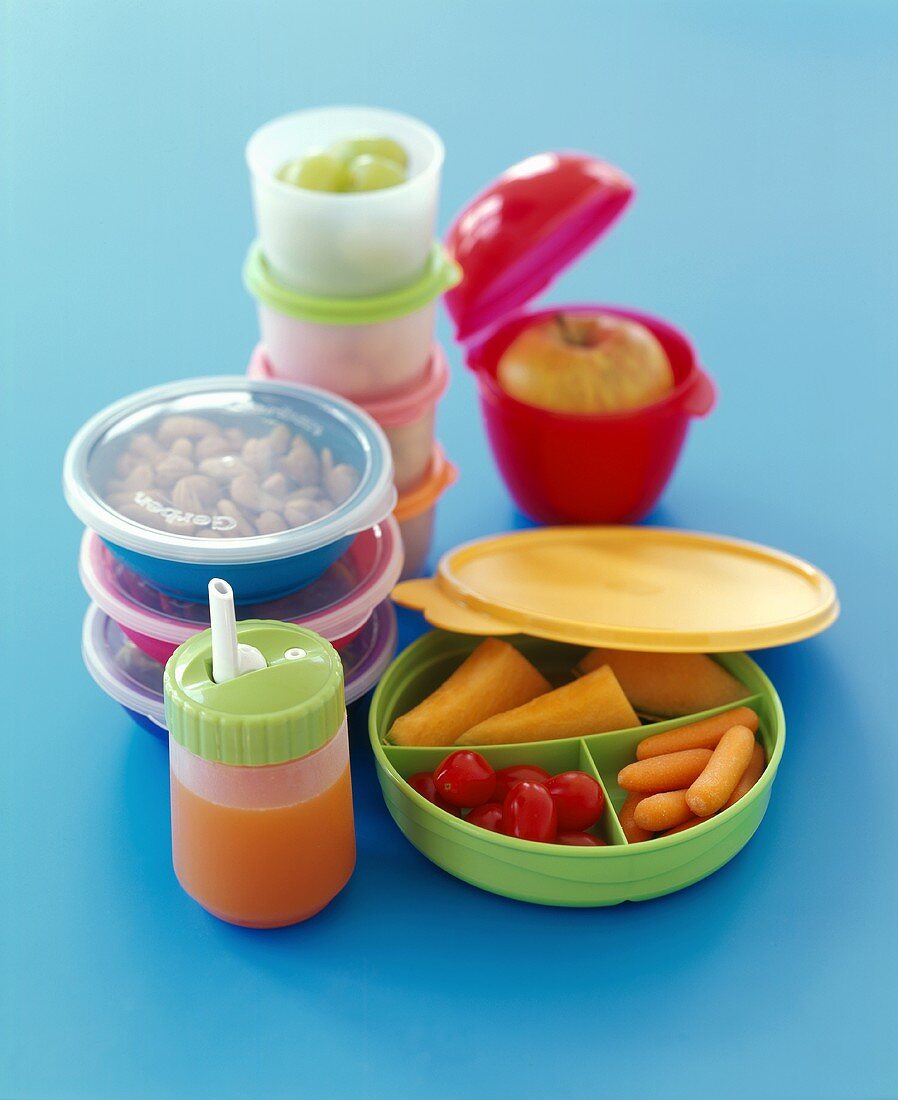 Tupperwarebehälter mit Gerichten, Obst, Gemüse und Saft