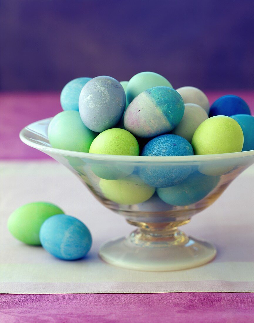 Blau und grün gefärbte Eier in Glasschale