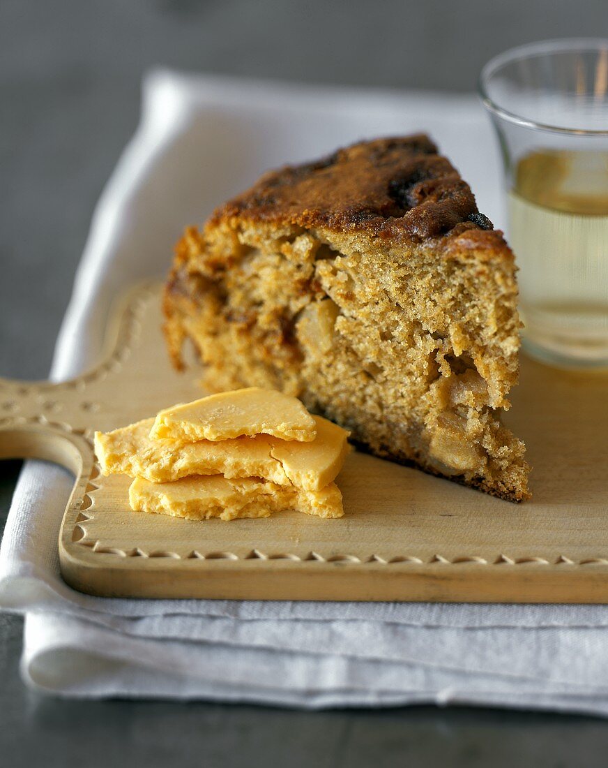 Piece of apple cake and Cheddar on chopping board