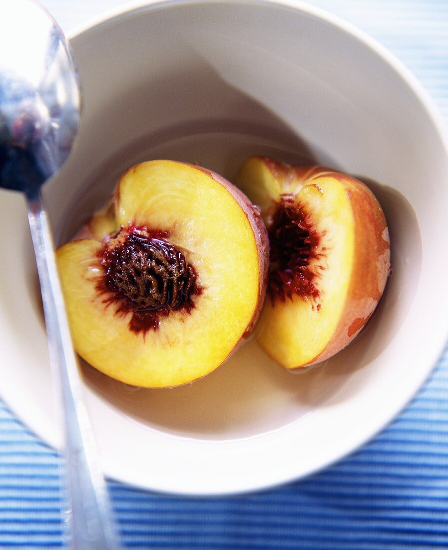 Nectarine Halves in a Bowl with a Spoon
