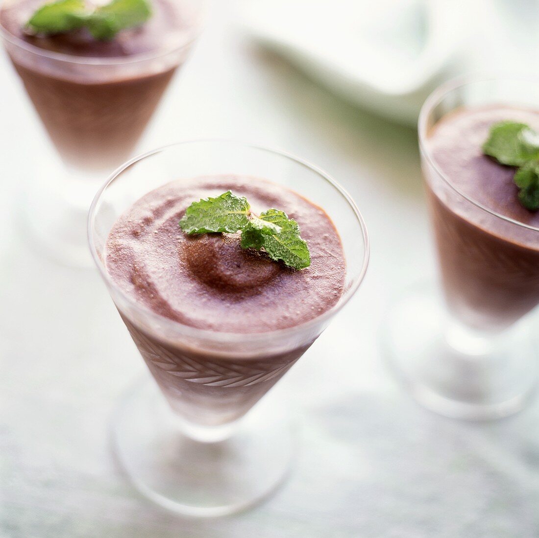 Blackberry ice cream, with mint garnish, in dessert glasses