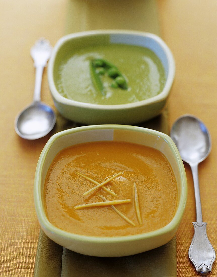 Carrot soup and pea soup in square soup bowls