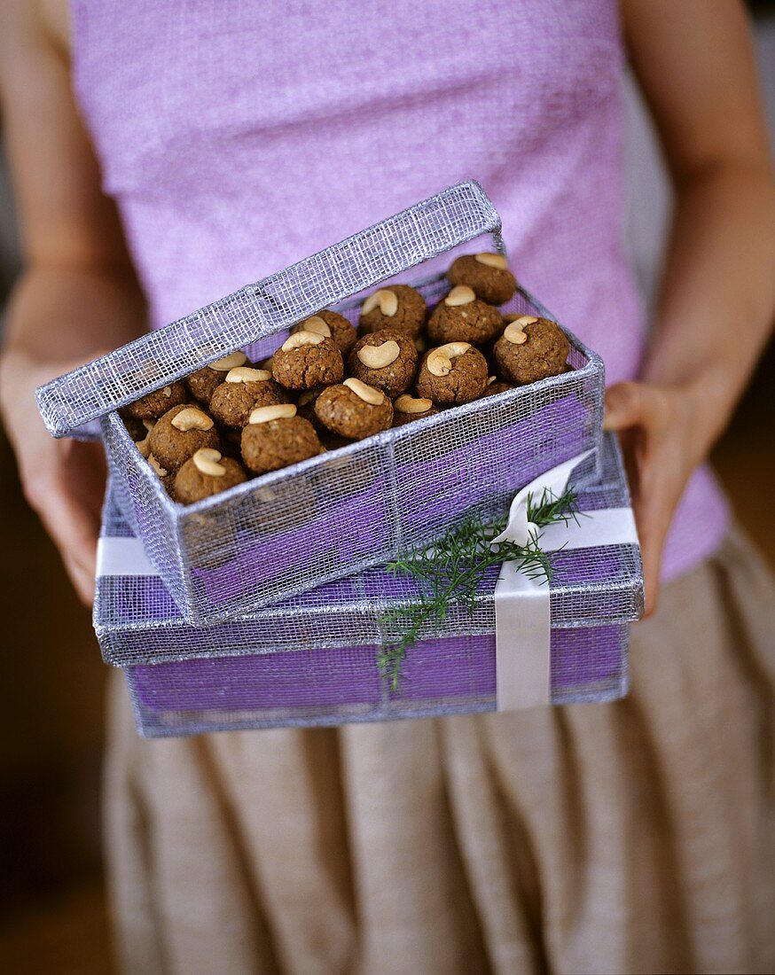 A Woman Holding Gift Boxes with Cashew Spice Cookies