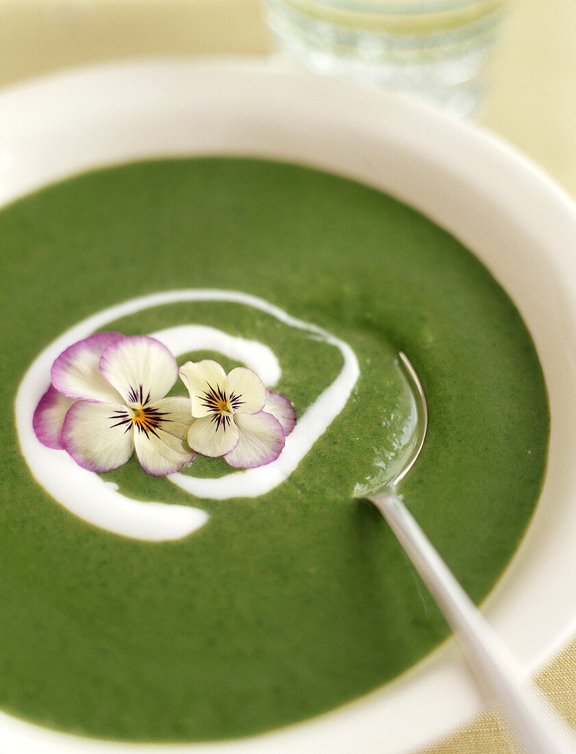 Spinach soup with pansies and crème fraîche