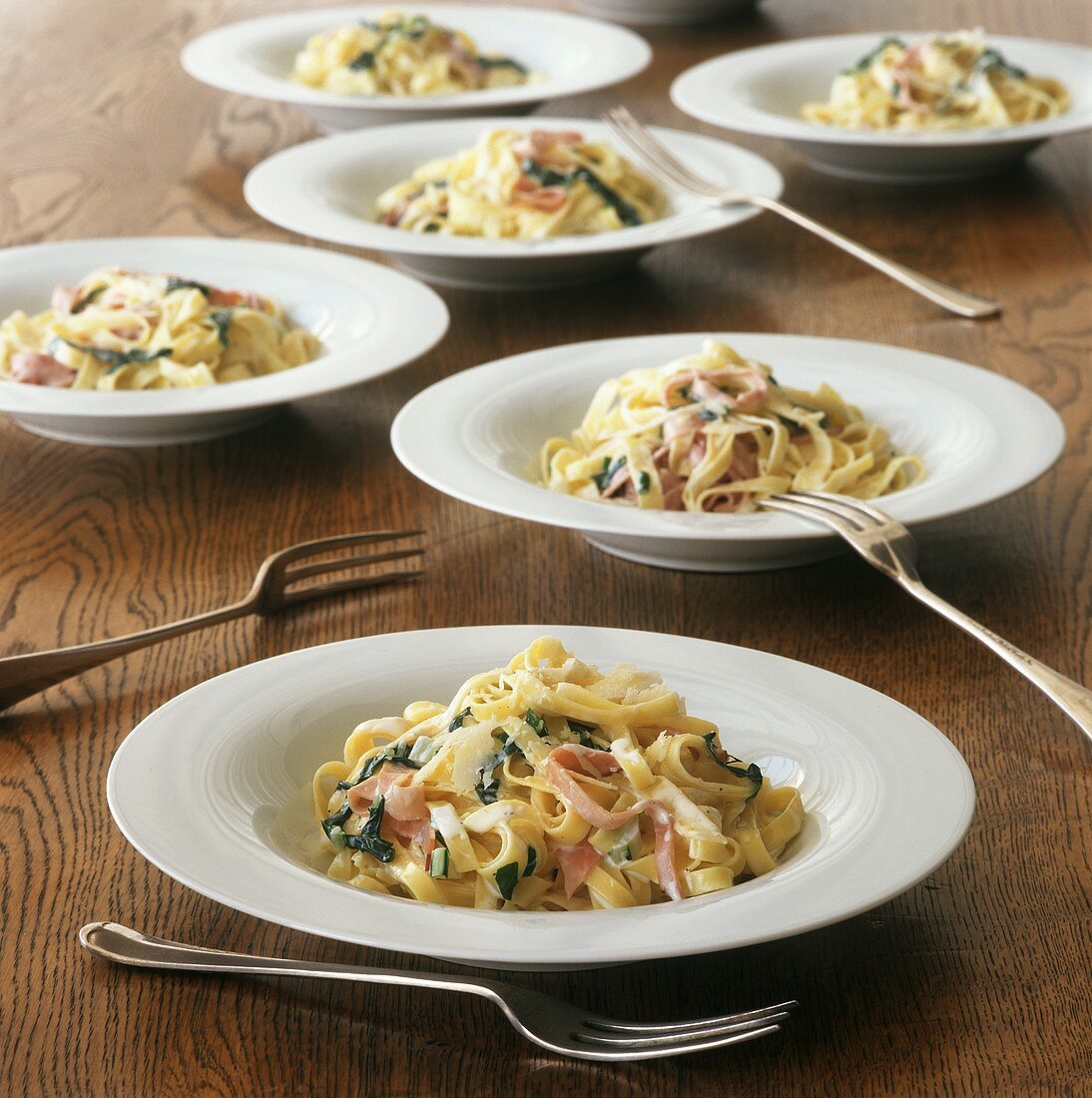 Bowls of Fettucini with Parmesan Cream Sauce, Sliced Ham and Spinach