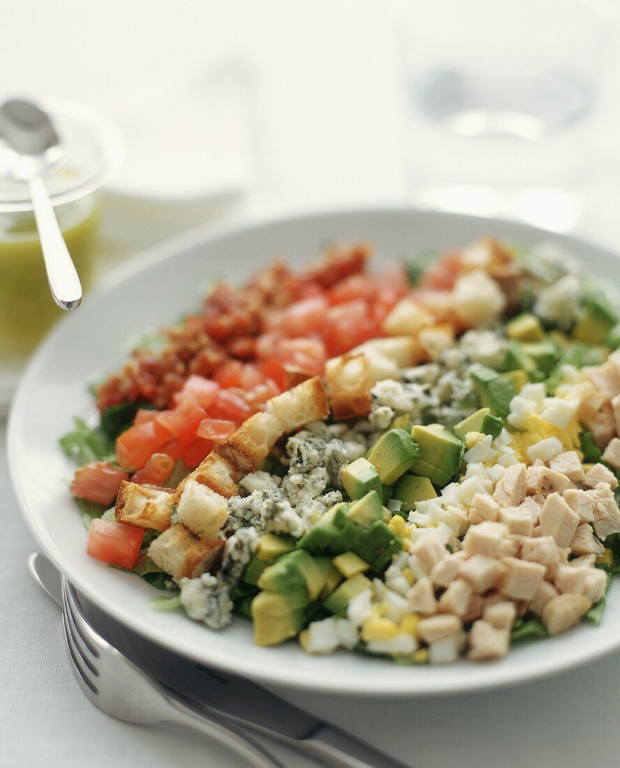 Salat aus gehacktem Gemüse, Käse, Hähnchen, Ei und Croûtons