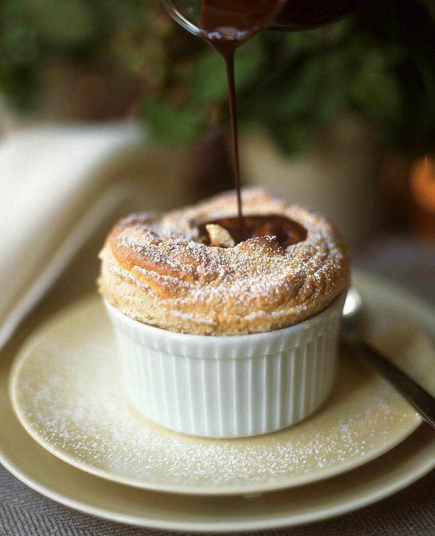 Vanillesouffle mit Schokoladensauce begiessen