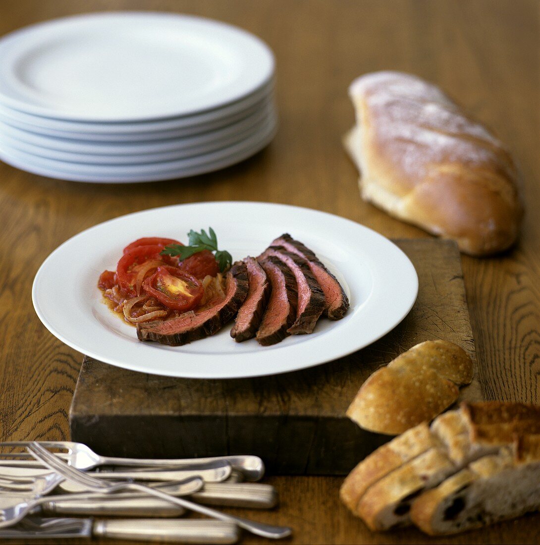 Rindfleischscheiben mit Tomaten und Zwiebeln; Olivenbrot