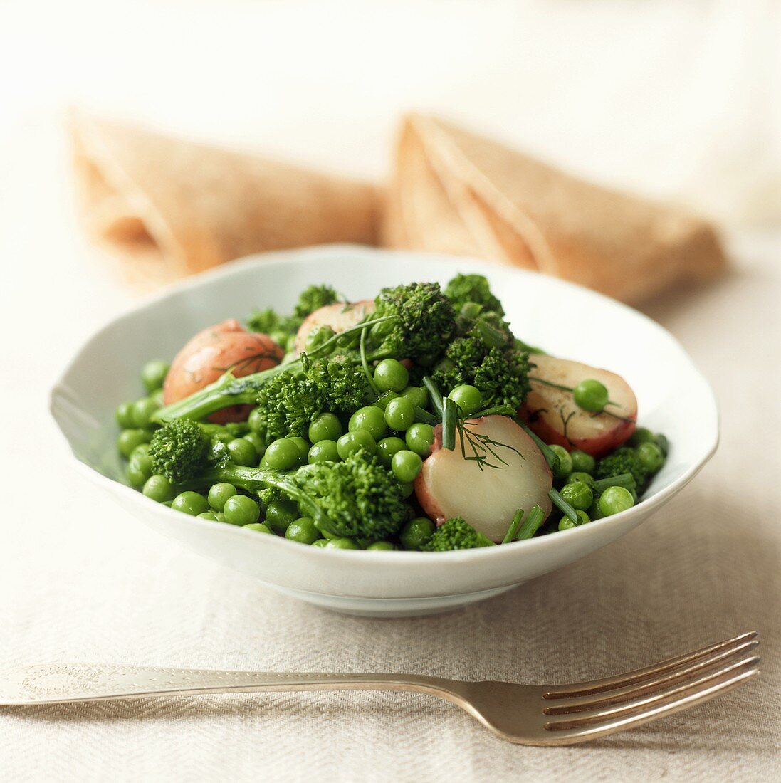 Peas, broccoli and red potatoes in white dish