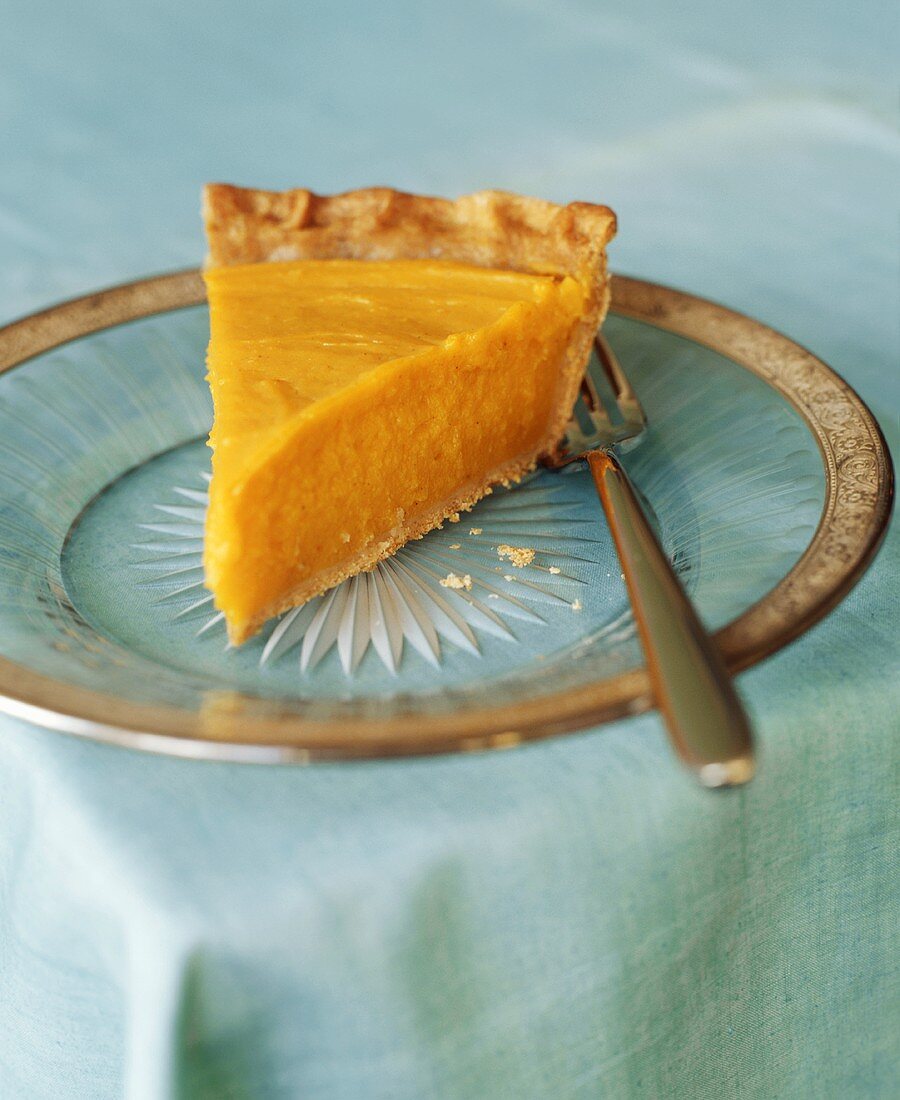 A slice of pumpkin pie with fork
