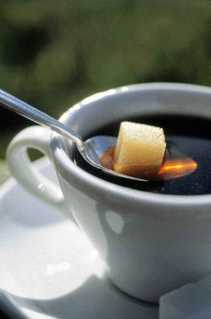 Zuckerwürfel auf Löffel in einer Kaffeetasse