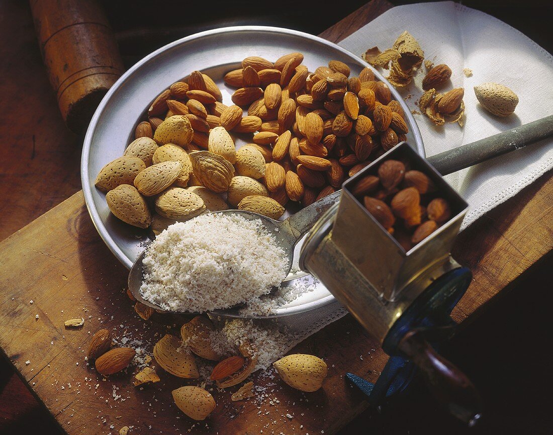Whole and Shelled Almonds on a Plate; Ground Almonds on a Spoon