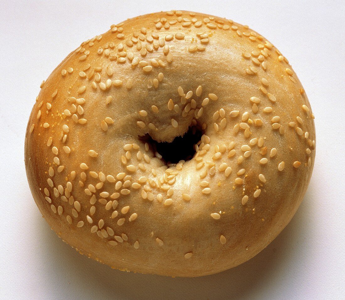 Ein Sesambagel auf weißem Untergrund