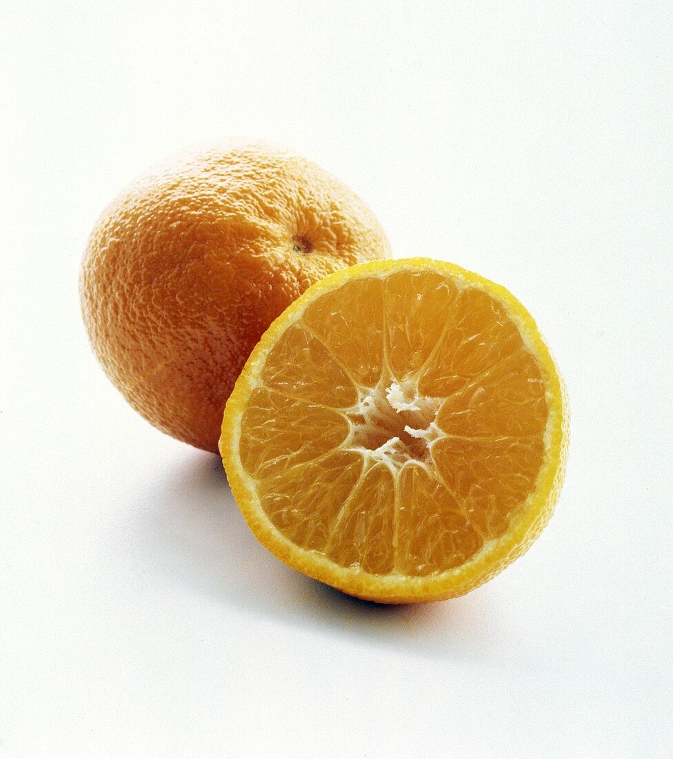 Eine ganze Clementine, davor halbierte Clementine