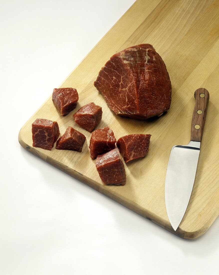 A Piece of Beef Half Chopped on a Cutting Board