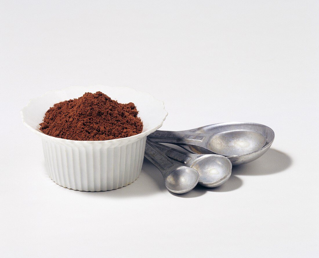 Cocoa Powder in a Bowl with Metal Measuring Spoons