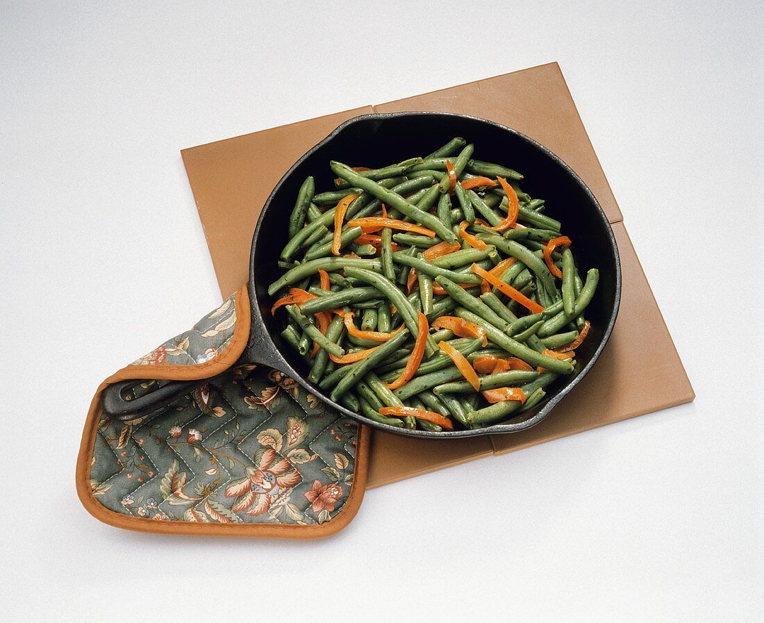 Sauteed Green Beans and Red Peppers in a Pan; Pot Holder