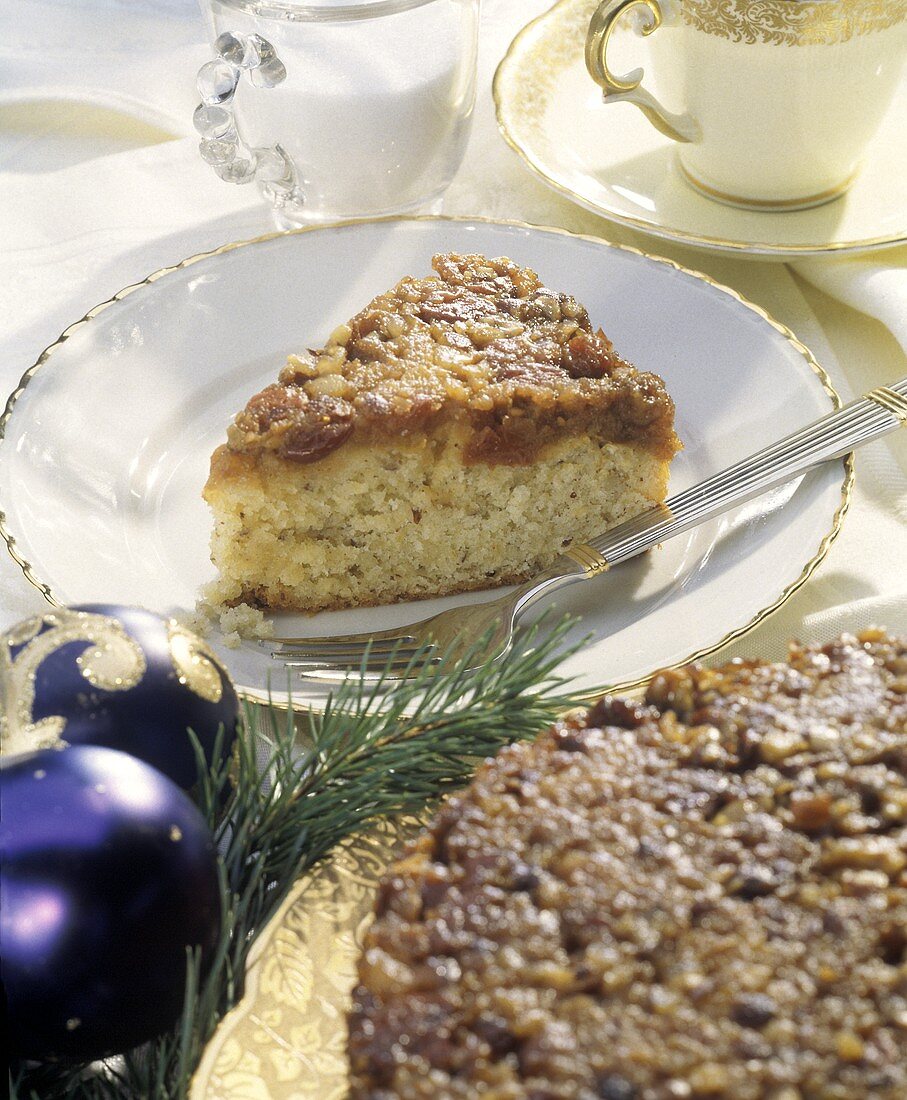 Stück Cranberrykuchen auf Teller; Weihnachtsdeko; Teetasse