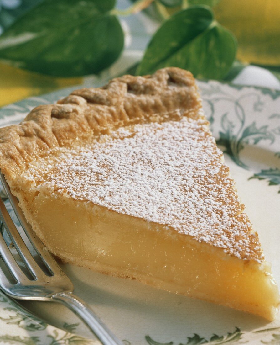 Stück Zitronenkuchen (Lemon Pie) mit Puderzucker auf Teller