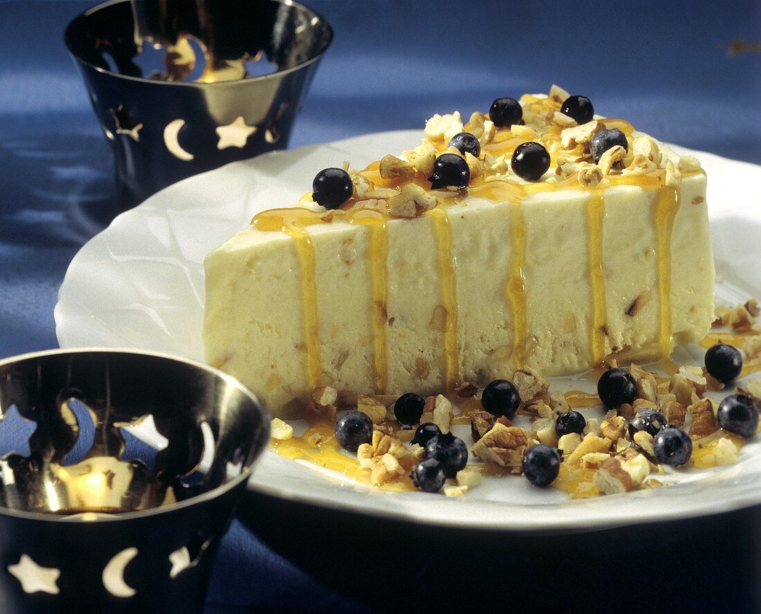 A Slice of Mousse Cake with Blueberries Orange Sauce and Nuts