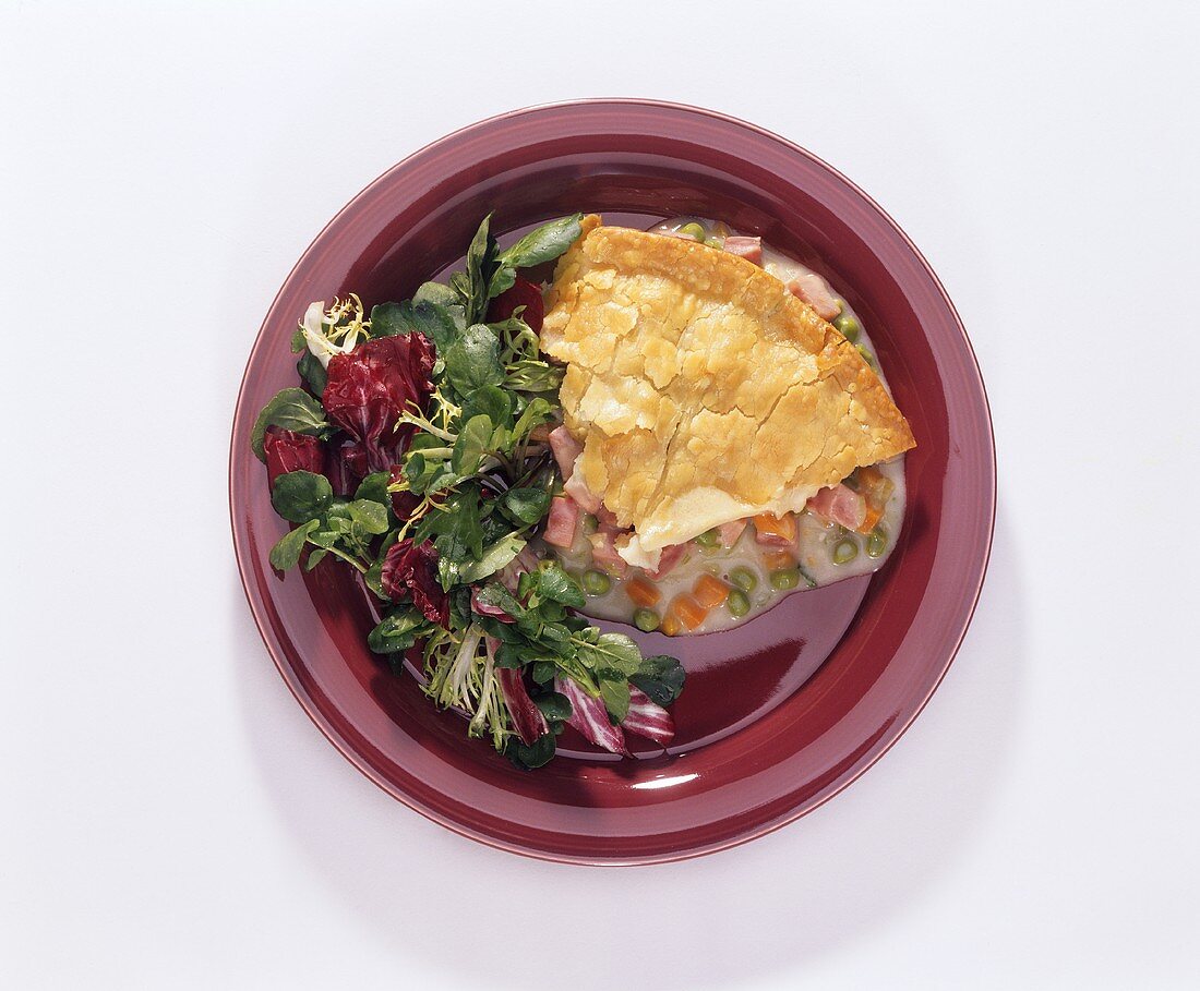 A Slice of Ham Pot Pie on a Plate with Salad