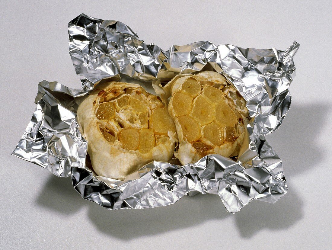 Two Bulbs of Roasted Garlic in Aluminum Foil