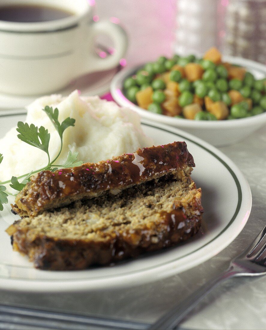 Zwei Scheiben Hackbraten mit Kartoffelpüree auf Teller