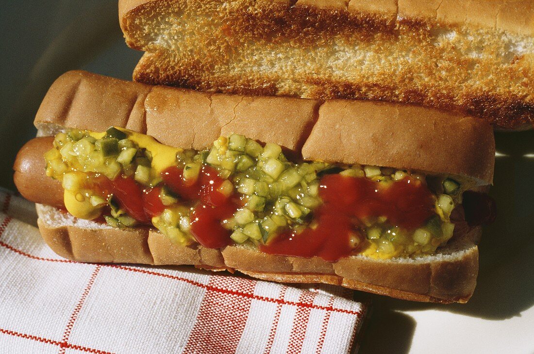 A Hot Dog with Ketchup Mustard and Relish; Grilled Bun