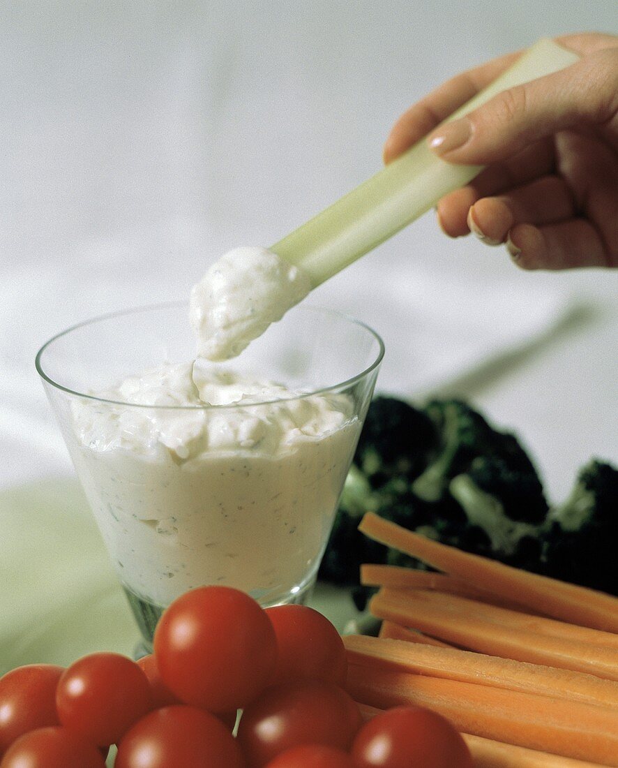 Vegetable Platter; Hand Dipping Celery Stick into Dip