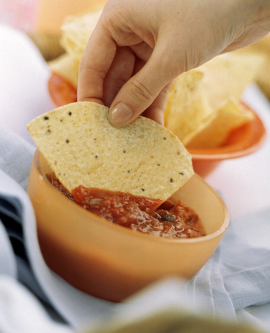 Hand Scooping Salsa with a Chip
