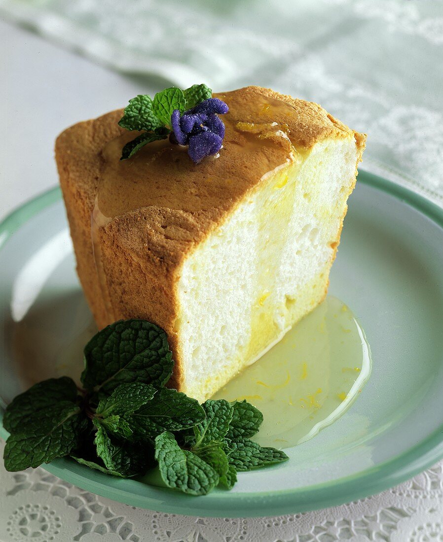 Ein Stück Biskuitkuchen (Angel Food Cake) mit Veilchen