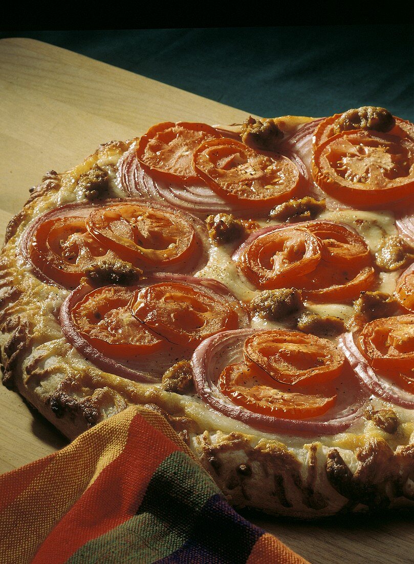 Pizza mit Tomaten, roten Zwiebeln und Fleischklösschen