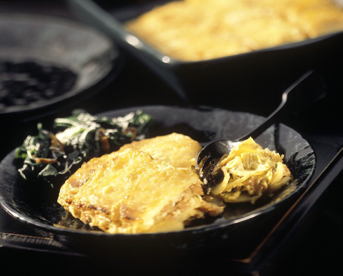 Kartoffelgratin mit Salat auf Teller mit Gabel