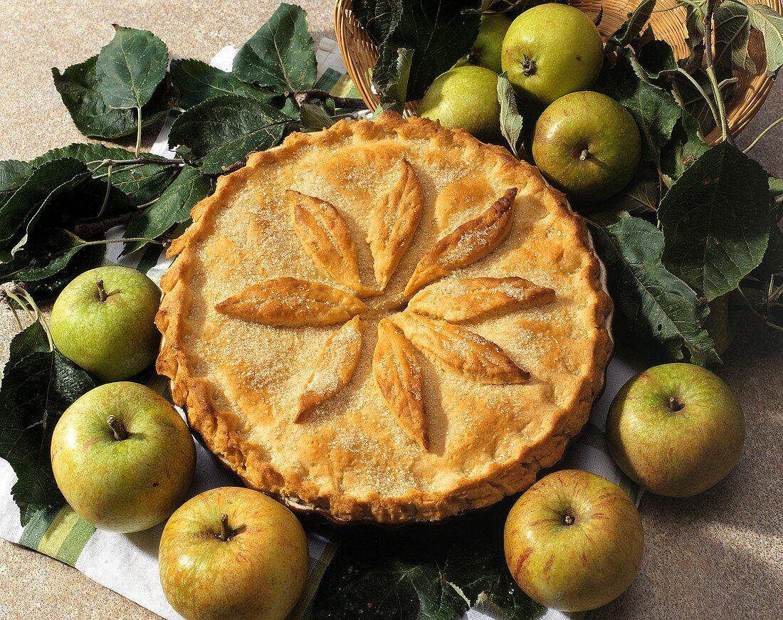 Appel Pie in der Backform und einige grüne Äpfel daneben
