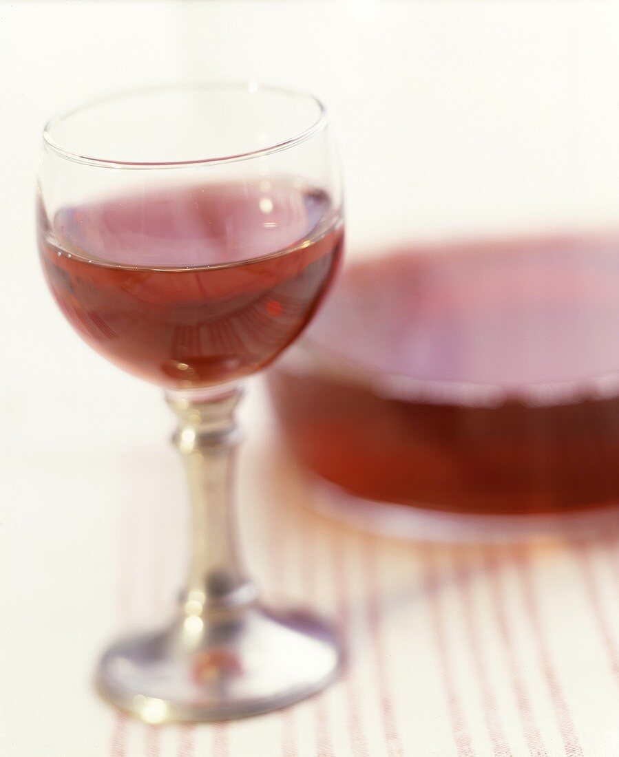 Ein Glas Rotwein vor einer Karaffe