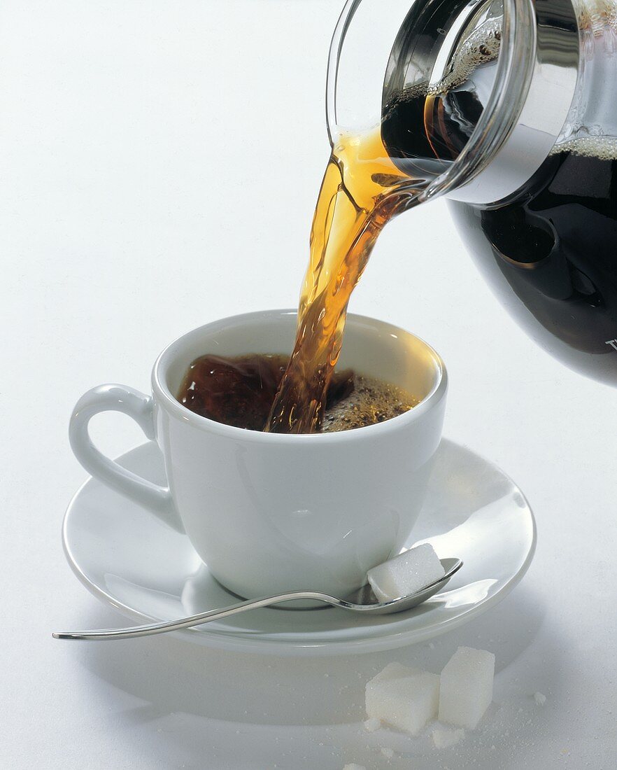 Kaffee in eine Tasse gießen