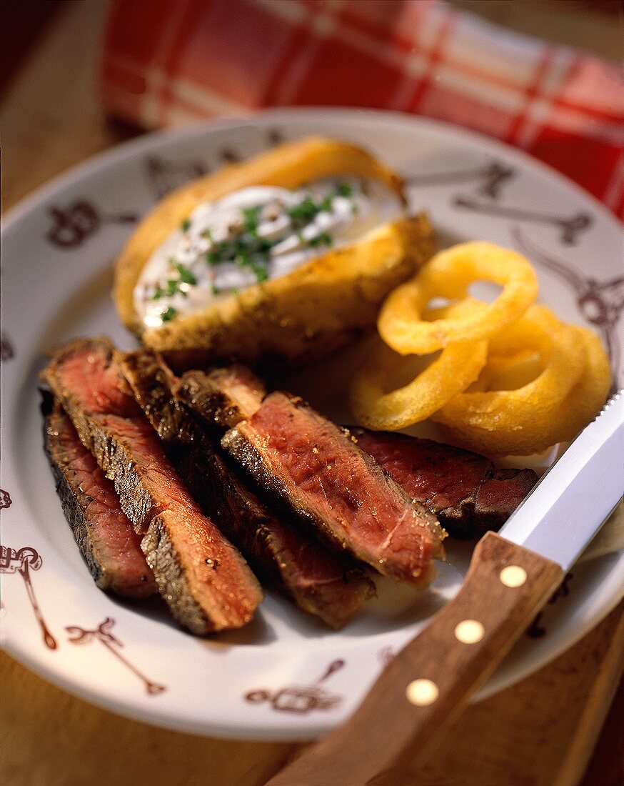 Steak, kleingeschnitten, mit Ofenkartoffel & Zwiebelringen