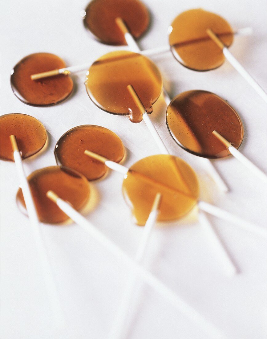Several caramel lollipops on a white surface