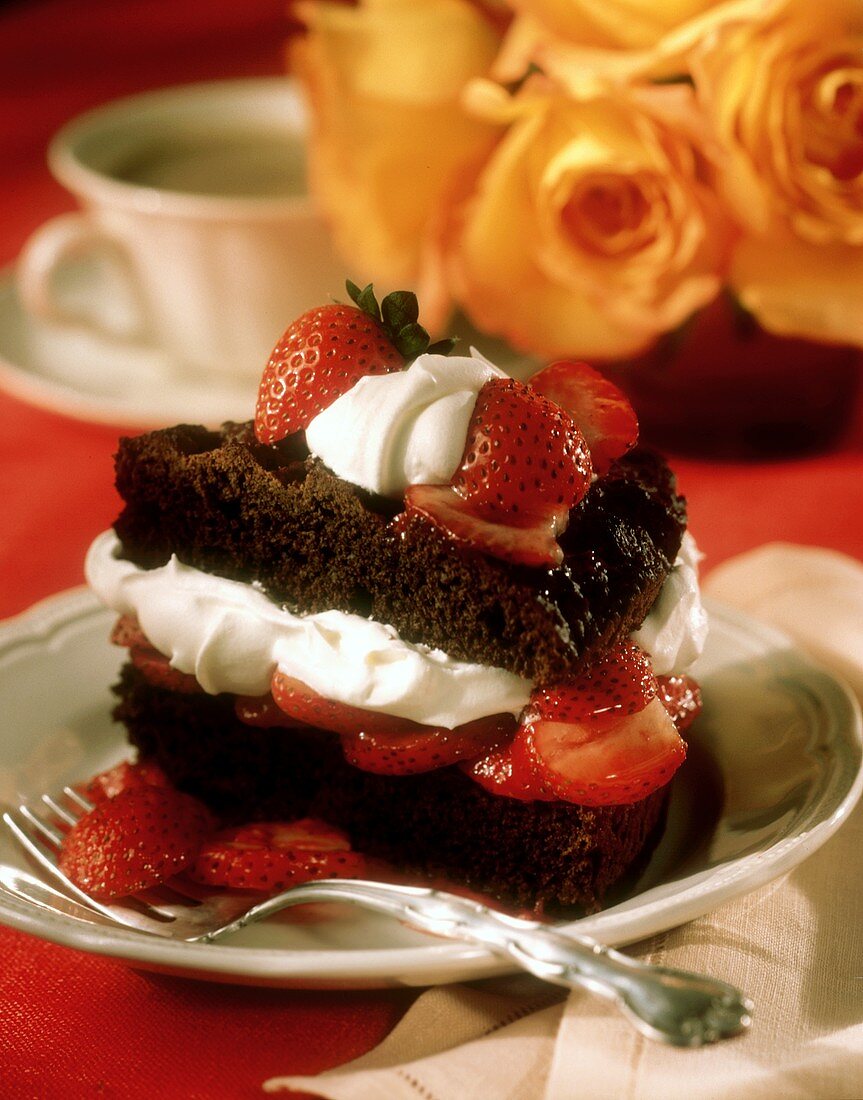 Ein Stück Schokoladenkuchen gefüllt mit Sahne und Erdbeeren