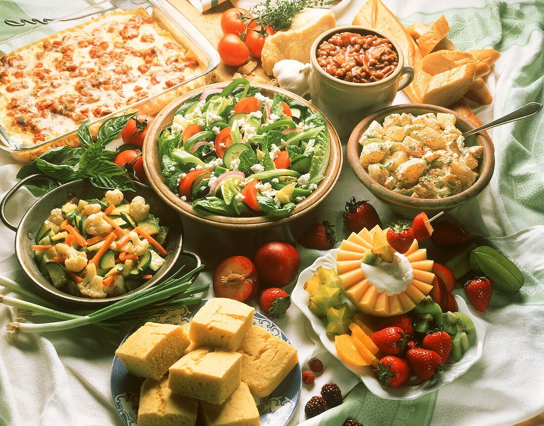 Buffet mit Salaten, Lasagne, Maisbrot, Bohnensuppe, Früchten