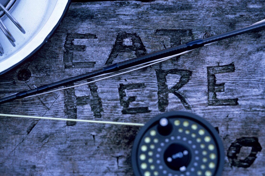 Eat Here Carved into a Picnic Table; Fishing Pole