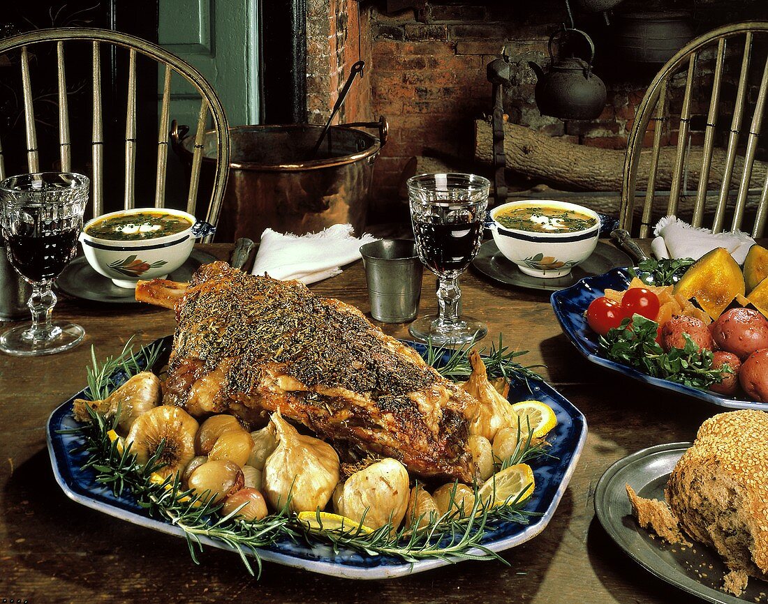 Gebratene Lammkeule mit Knoblauch und Zwiebeln am Tisch