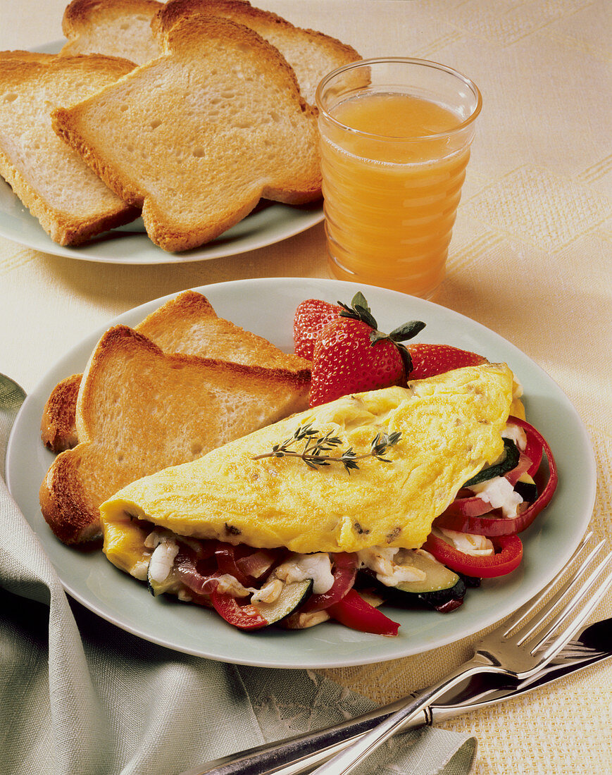 Omelett mit Gemüsefüllung, Toast und Erdbeeren; Vitaminsaft