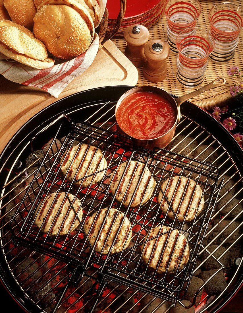 Geflügelfrikadellen für Hamburger auf dem Grill; Tomatensauce