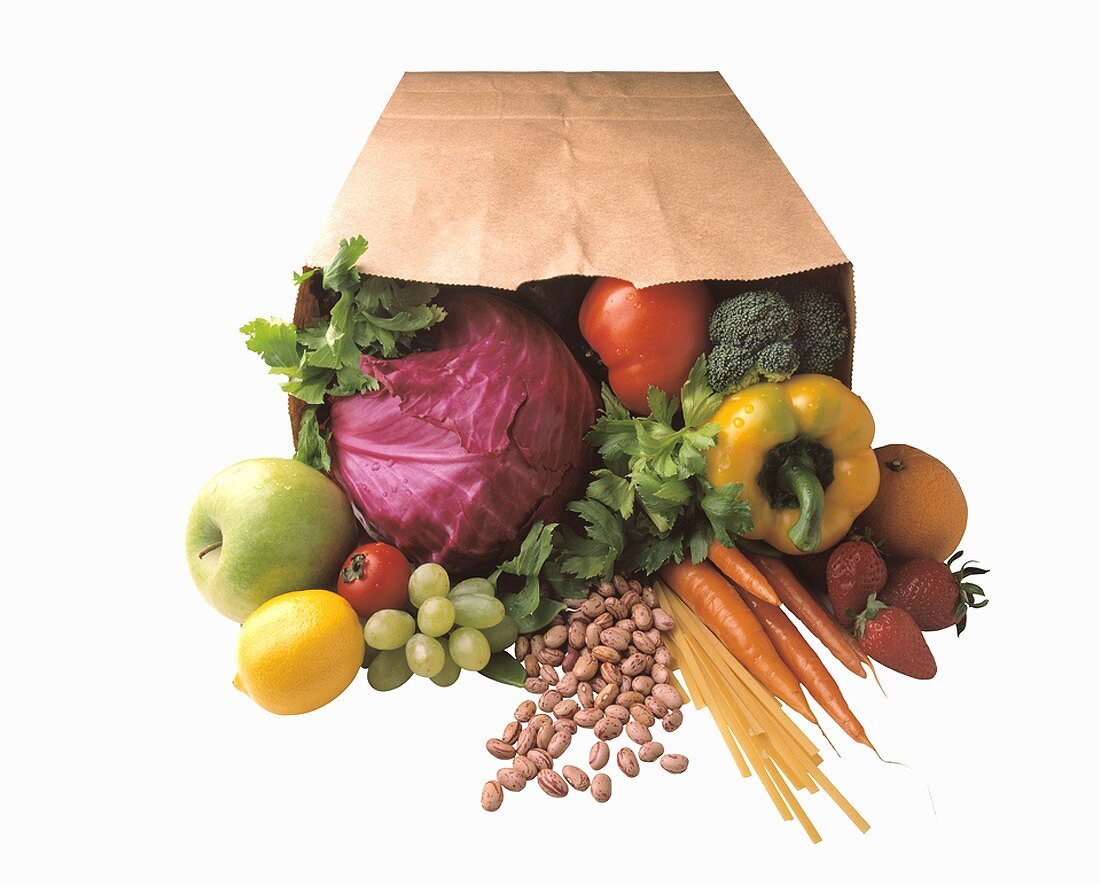 Vegetables, fruit, herbs and pasta in a paper bag
